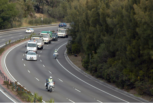 Photograph showing vehicles moving currency under police protection.