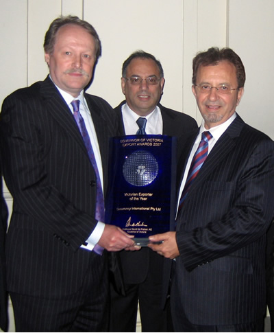 Photograph: Securency International was awarded the Victorian Exporter of the Year in 2007. Myles Curtis, Managing Direcotr, Securency International (left), receives the award from the Hon. Theo Theophanous, Victorian Minister for Industry and Trade (right), with Joseph Mamo, CFO & Director of Strategic Planning, Securency International (centre).