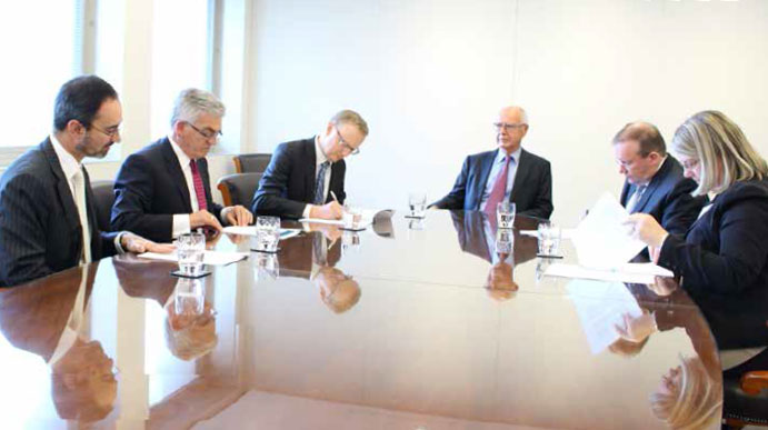 Chair of the Reserve Bank Board Audit Committee John Akehurst (centre) observes as Governor Philip Lowe (third from left) signs the Reserve Bank's accounts for 2016/17 while the Auditor-General for Australia, Grant Hehir (second from right), signs his audit opinion; also present (from left) Reserve Bank Secretary Anthony Dickman, Assistant Governor (Corporate Services) Frank Campbell and Australian National Audit Office Group Executive Director Jocelyn Ashford