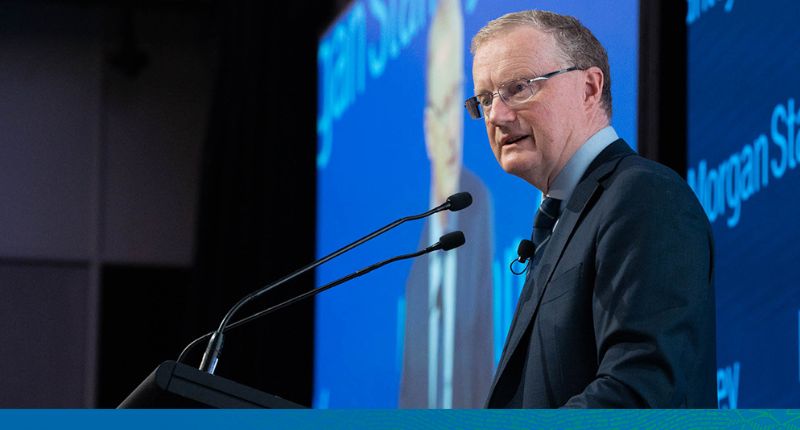 Philip Lowe speaking behind a lectern with 2 microphones. Behind him are large screens with the Morgan Stanley logos.