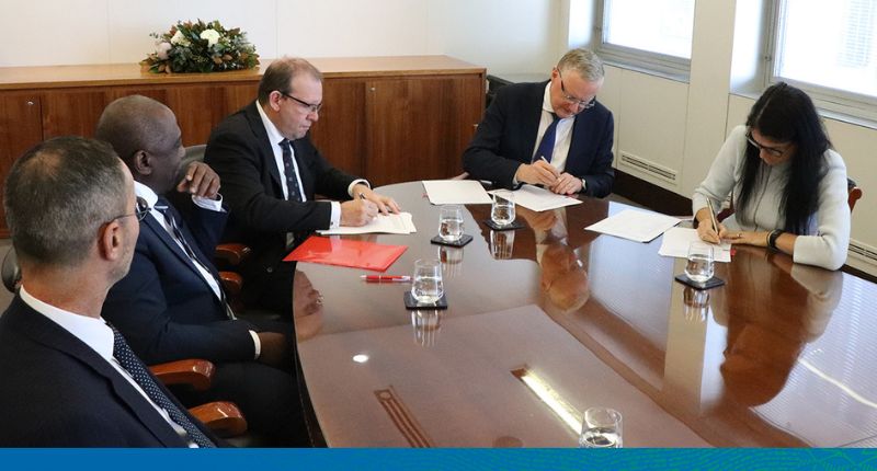 Five people sitting around an oval table. Phil and Emma from the RBA and the Auditor General signing the financial statements.