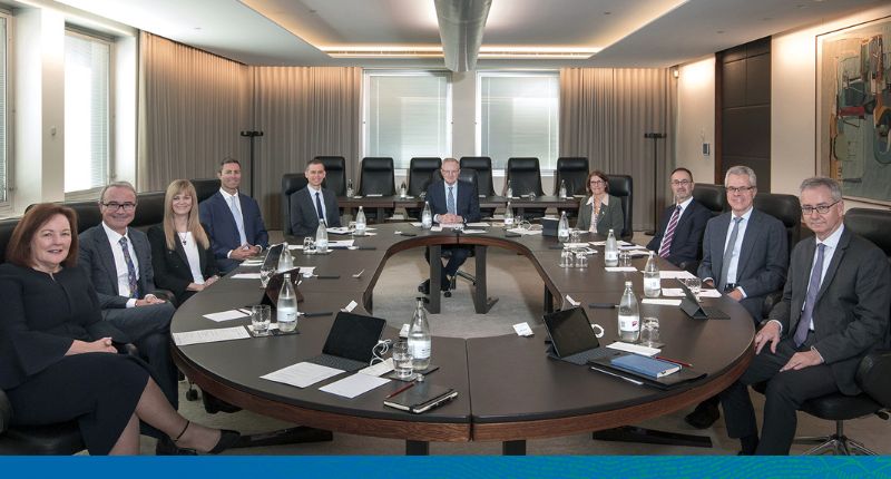 Photo of the Payment System Board members sitting around the large oval board room table, smiling, and looking at the camera.