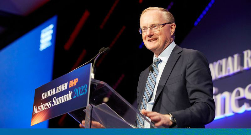 Photograph of Dr Lowe speaking behind the lectern smiling.