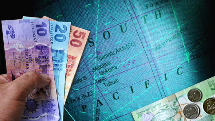 Image of a map with a hand in the foreground holding Fijian currency