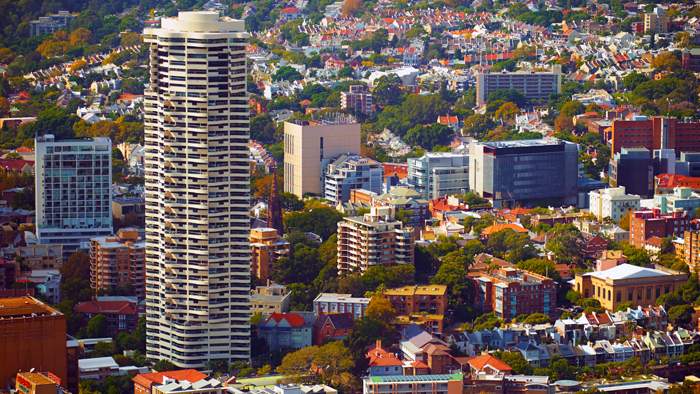 A highrise building stands out among lower suburb buildings.