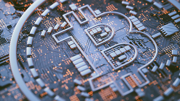 The symbol of Bitcoin is juxtaposed to an electronic circuit board