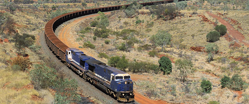 A long mining train snakes its way through dry country