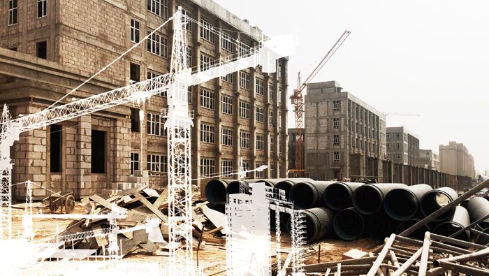 A housing construction site with crane silhouettes superimposed on the image.